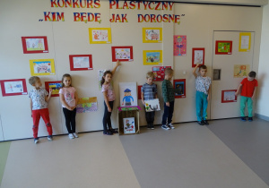 sześciolatki pozują przy wystawie swoich prac